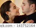 Couple sharing a romantic moment indoors with soft lighting 143752164
