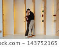 Couple enjoying a joyful moment together in a modern indoor space 143752165