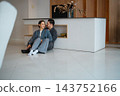 Couple enjoying time together in modern living room during daytime 143752166