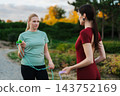 Two women engage in outdoor fitness training during a sunny afternoon 143752169