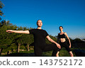 Women practicing yoga outdoors under a clear blue sky in the morning 143752172