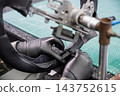 A seamstress in a workshop makes a new leather cover for a car steering wheel. 143752615