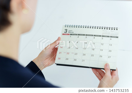 一位女商人正盯著日曆看。 143753235