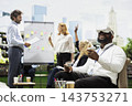 Virtual reality, headset and controllers as businessman explores VR while colleagues discuss whiteboard plans. Innovation, simulation and collaboration connect immersive tech with outdoor workshop. 143753271