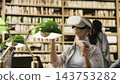 VR headset, student and controller show woman reaching out during immersive activity at a library desk. Simulation, interactive learning and education technology suggest experimental study methods. 143753282