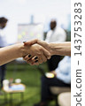 Handshake, agreement and partnership as professionals clasp hands during outdoor business meeting. Trust, networking and collaboration suggest positive project discussion in urban workspace. 143753283