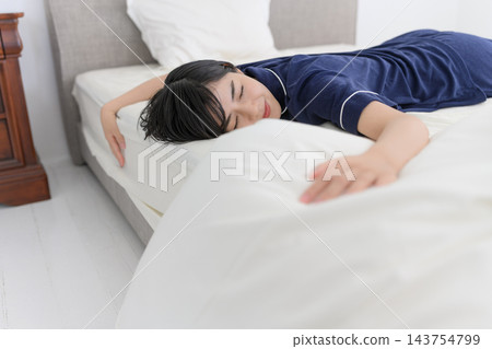 一個女人疲憊地睡在床上 143754799