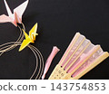 A fan and a gold mizuhiki (decorative cord) in the background, with an origami crane. 143754853