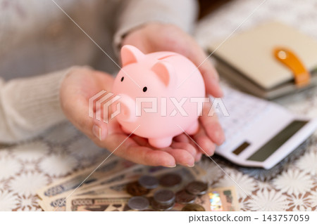 中老年婦女拿著粉紅色小豬存錢罐 143757059