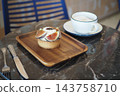 Fig-topped pastry and coffee served on a cafe table 143758710