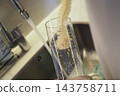 Cleaning Glass With Bottle Brush in Kitchen Sink Under Running Water for Sparkling Glassware 143758711