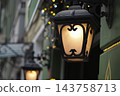 Wall lanterns lighting a building facade on a city street at night 143758713