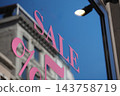 Sale lettering on a shop window with a building reflected in daylight 143758719