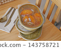 Stacked takeaway meal containers with soup on a wooden table 143758721