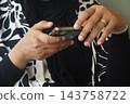 Woman using a smartphone while wearing a ring and bracelet 143758722