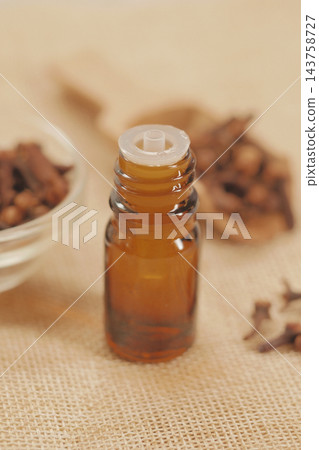 Amber glass bottle with a dropper cap on a burlap surface Amber glass bottle with a dropper cap on a burlap surface 143758727