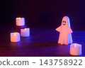 Halloween image with ghosts and candles (using colored lights and filters) 143758922