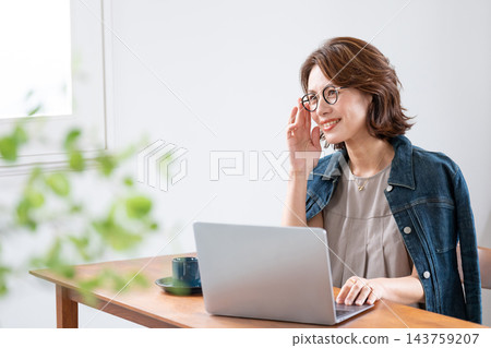 在客廳裡使用電腦的中年女人 143759207