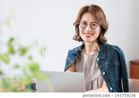 在客廳裡使用電腦的中年婦女 143759236