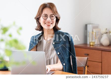 在客廳裡使用電腦的中年婦女 143759237