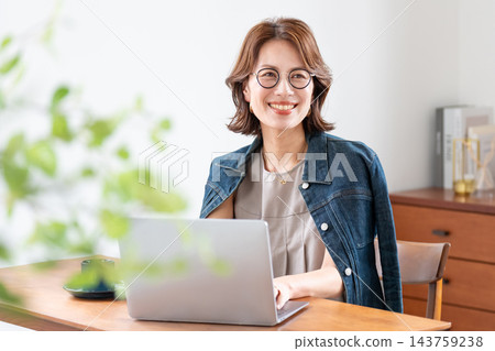 在客廳裡使用電腦的中年婦女 143759238