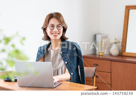 在客廳裡使用電腦的中年女人 143759239