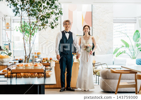 新郎新娘手牽手進入婚宴現場。 143759300
