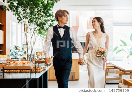新郎新娘手牽手進入婚宴現場。 143759309