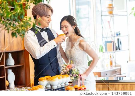 新郎新娘在婚宴自助餐上分享他們的第一口食物。 143759991