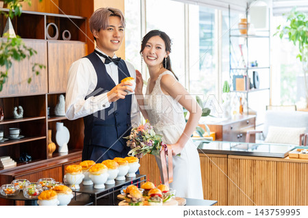 新郎新娘在婚禮宴席上對著食物微笑。 143759995