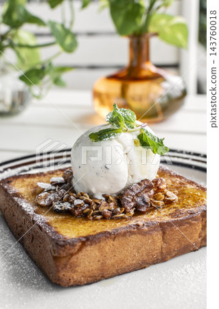 gourmet sweet french toast with madagascar vanilla ice cream and organic honey roasted granola on white cafe table outdoor gourmet sweet french toast with madagascar vanilla ice cream and organic honey roasted granola on white cafe table outdoor 143760018