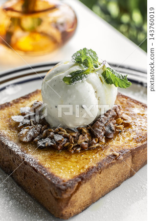 gourmet sweet french toast with madagascar vanilla ice cream and organic honey roasted granola on white cafe table outdoor gourmet sweet french toast with madagascar vanilla ice cream and organic honey roasted granola on white cafe table outdoor 143760019
