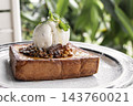 gourmet sweet french toast with madagascar vanilla ice cream and organic honey roasted granola on white cafe table outdoor 143760021