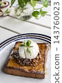 gourmet sweet french toast with madagascar vanilla ice cream and organic honey roasted granola on white cafe table outdoor 143760023