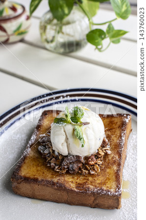 gourmet sweet french toast with madagascar vanilla ice cream and organic honey roasted granola on white cafe table outdoor gourmet sweet french toast with madagascar vanilla ice cream and organic honey roasted granola on white cafe table outdoor 143760023