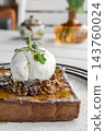 gourmet sweet french toast with madagascar vanilla ice cream and organic honey roasted granola on white cafe table outdoor 143760024