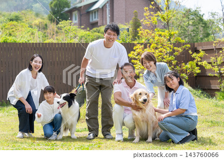 一家三代人在院子裡和他們的狗玩耍 一家三代人在院子裡和他們的狗玩耍 143760066