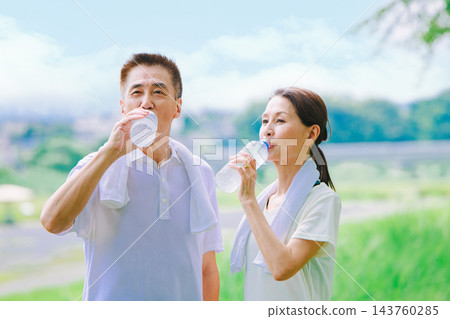 老年夫婦在運動中補充水分 老年夫婦在運動中補充水分 143760285