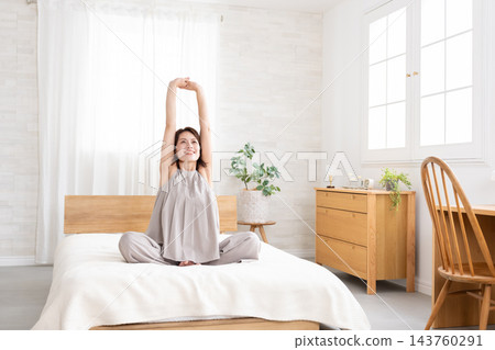 中年婦女在床上伸展身體 中年婦女在床上伸展身體 143760291