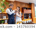 The bride and groom share their first bite at the wedding reception buffet. 143760394