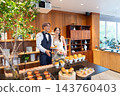 The bride and groom smile in front of the food at their wedding party. 143760403