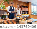 The bride and groom smile in front of the food at their wedding party. 143760406