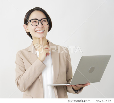 想像一下，一位中年女商人手持筆記型電腦，背景是白色。 143760546