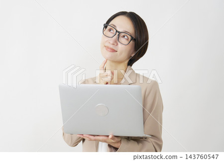 想像一下，一位中年女商人手持筆記型電腦，背景是白色。 143760547