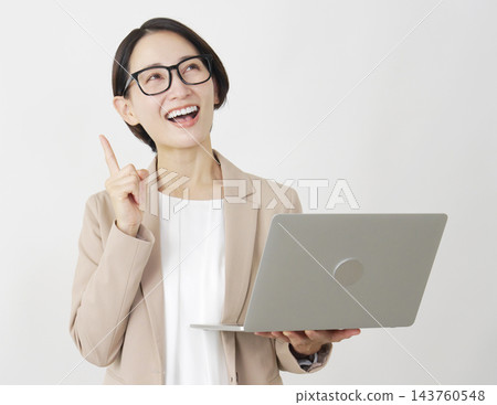 一位中年女商人手持筆記型電腦，神情專注，背景為白色。 143760548