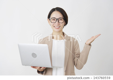 一位手持筆記型電腦的女商人，在白色背景下用手掌指向右側。 143760559
