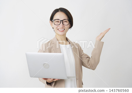 一位手持筆記型電腦的女商人，在白色背景下用手掌指向右側。 143760560