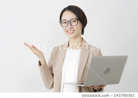一位手持筆記型電腦的女商人，在白色背景下用手掌指向左側。 143760561