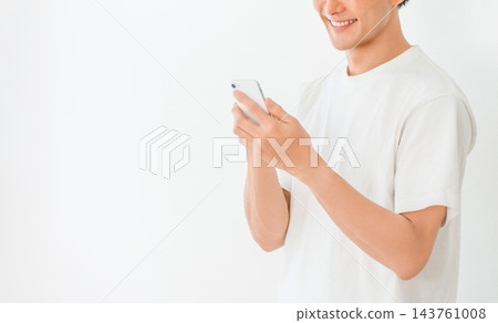 圖片顯示一名年輕男子正在使用智慧型手機發布詐欺和誹謗性內容。 143761008