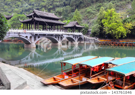 Fenghuang Ancient Town - tourist attraction in Hunan, China. Traditional chinese boats and old bridge in watertown Fenghuang - City of Phoenix. Summer topic of travel, trip, vacation 143761846